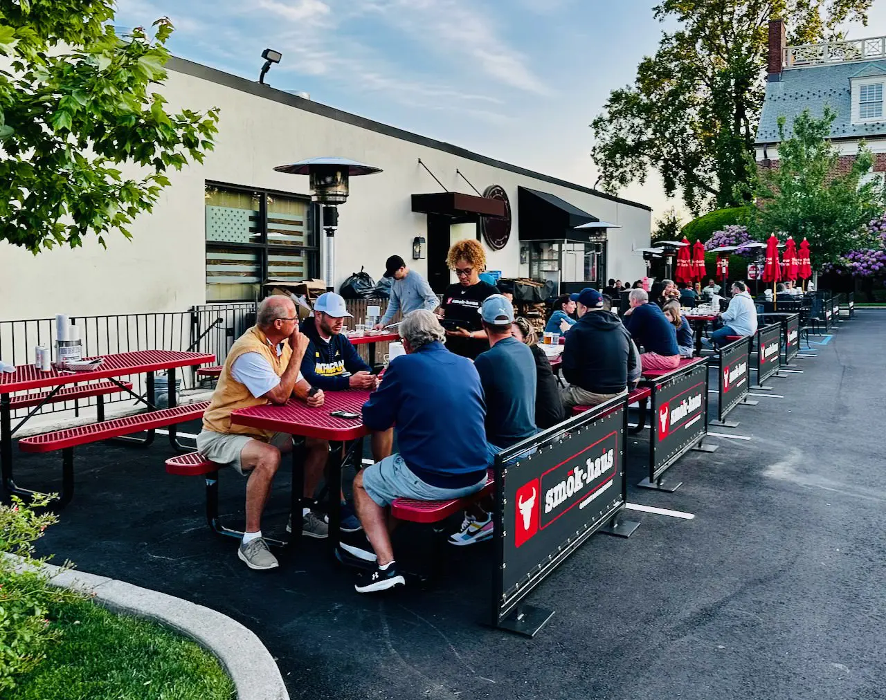 A group of people sitting at tables outside